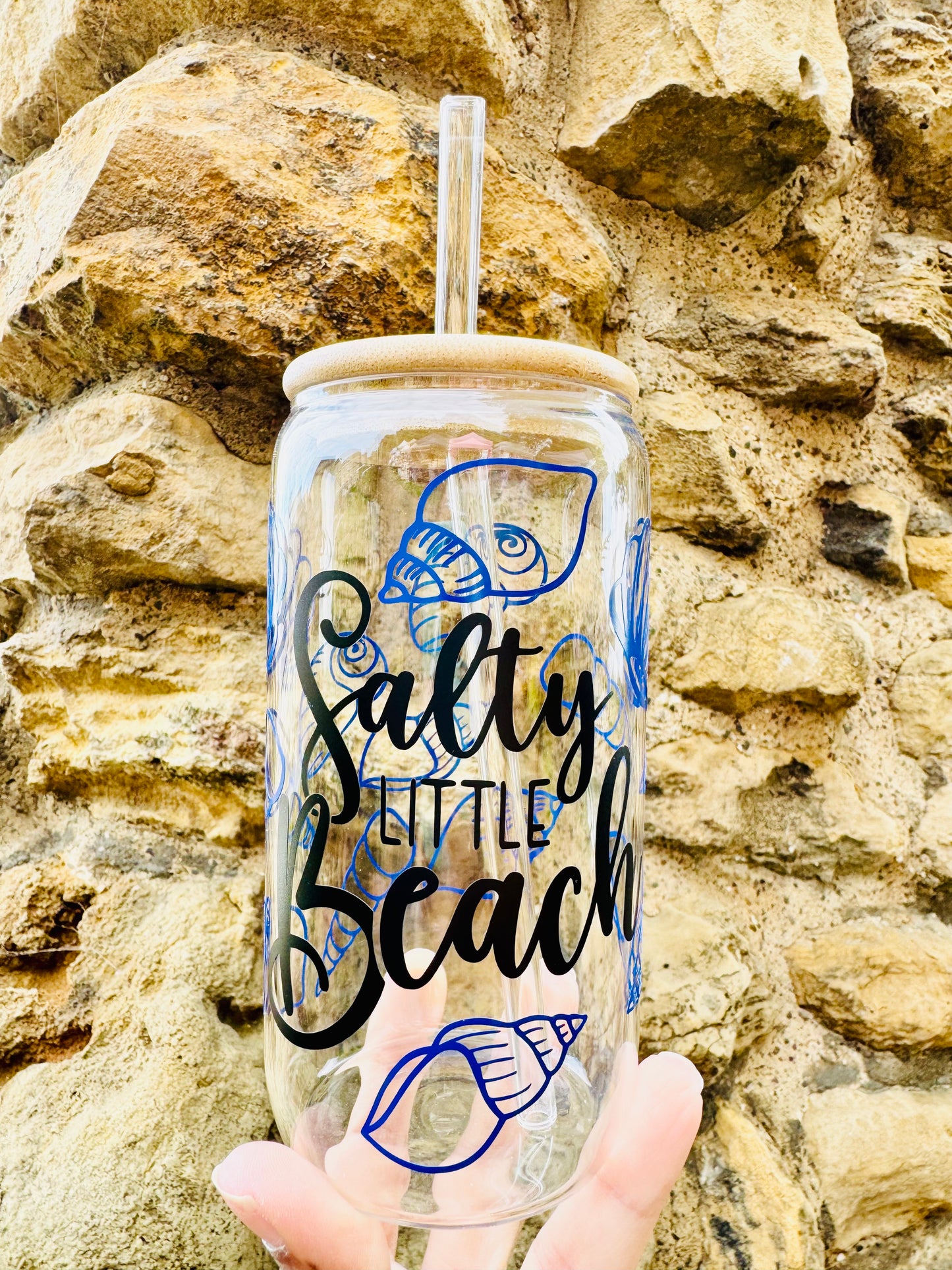 Glass Can Cup with salty little beach printed in a cursive black font with blue sea shells all around the glass