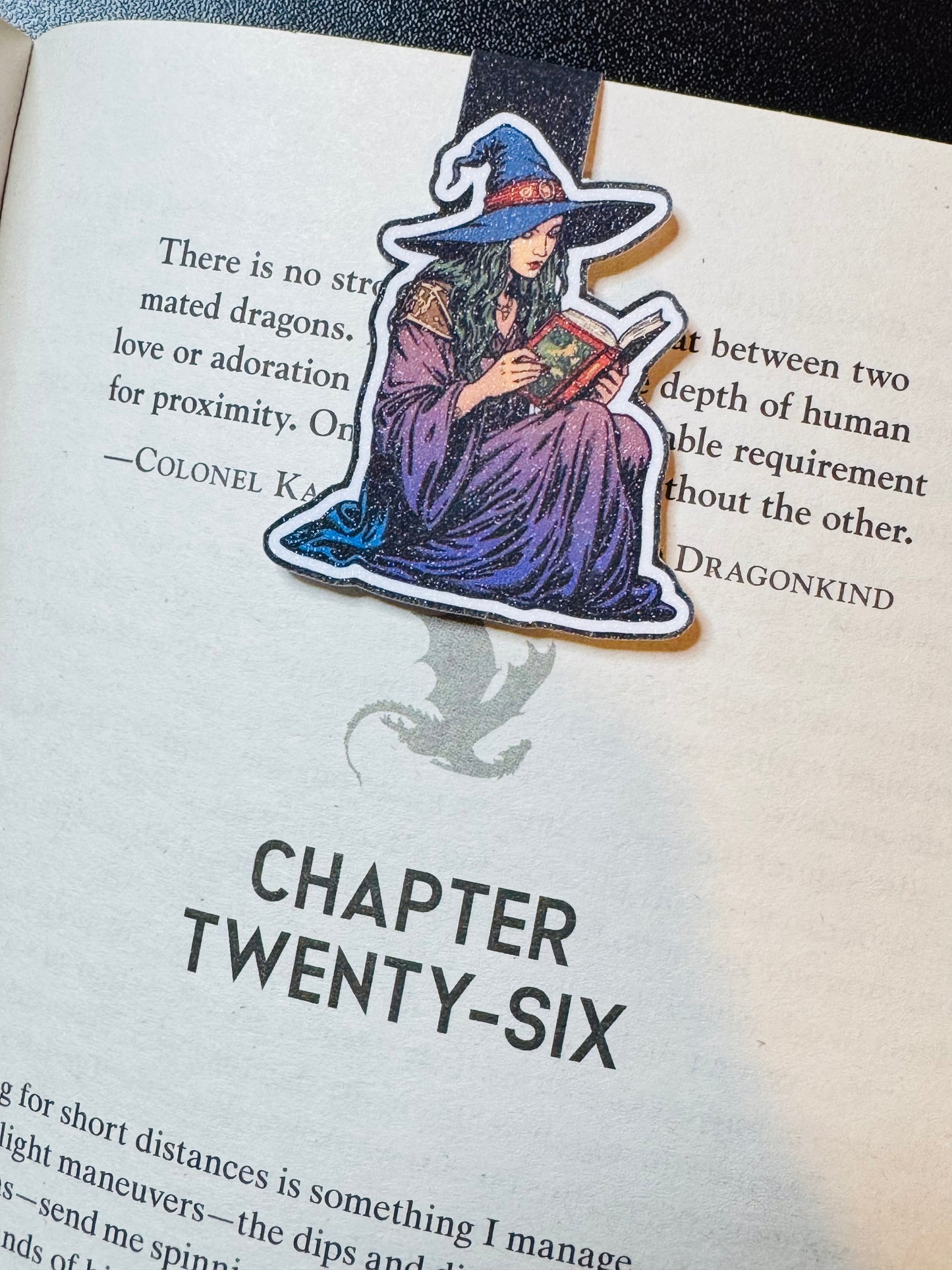 Book with a witch-themed bookmark on a page titled 'Chapter Twenty-Six'.