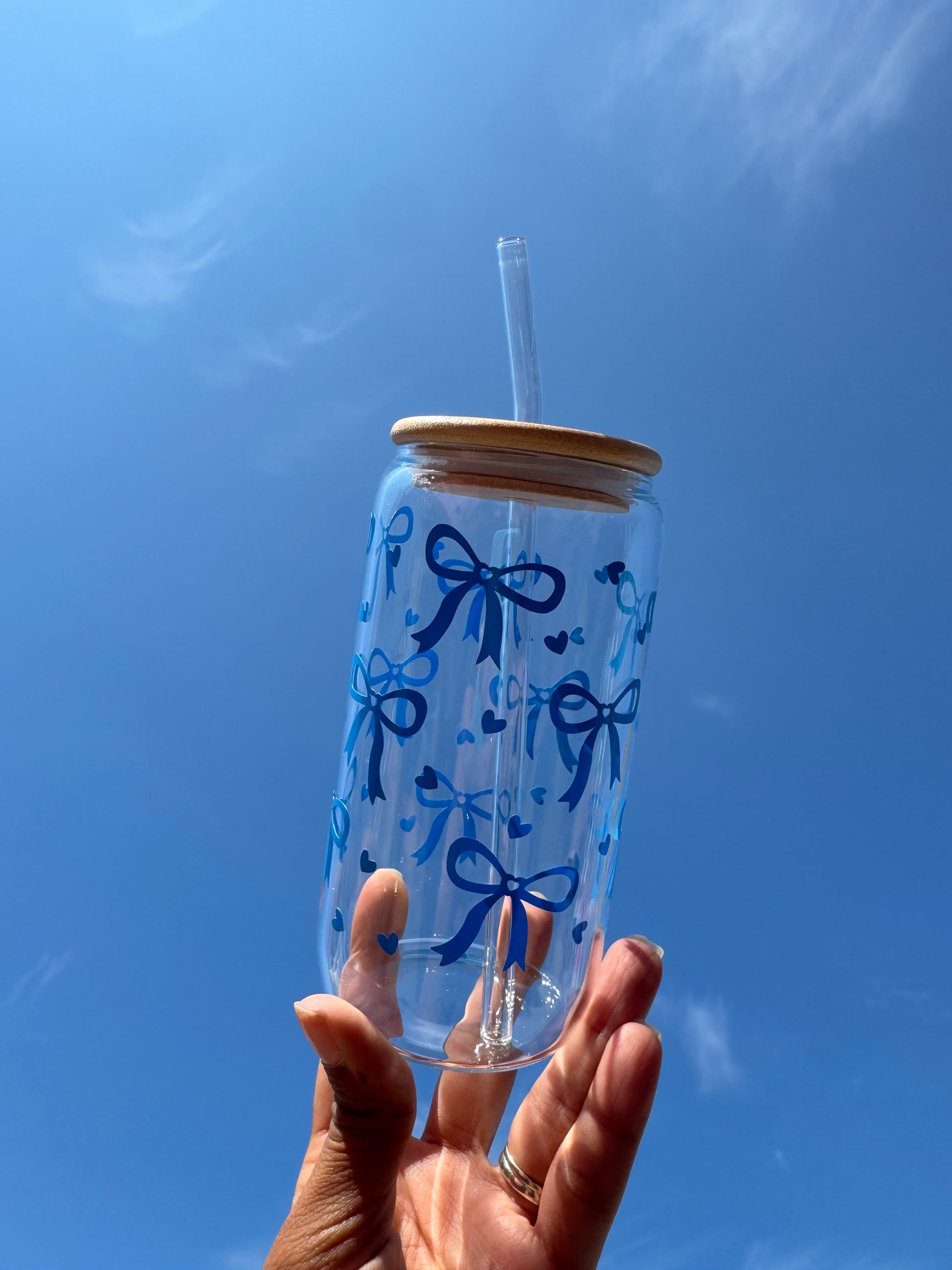 “Handmade clear glass decorated with a blue bow and heart design by JemmaRuth Designs, UK small business creating unique glassware and drinkware.”