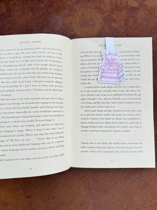 Magnetic bookmark featuring the phrase "Bookish Babe" in playful lettering, clipped over the top of a book page. A cute and practical gift for book lovers