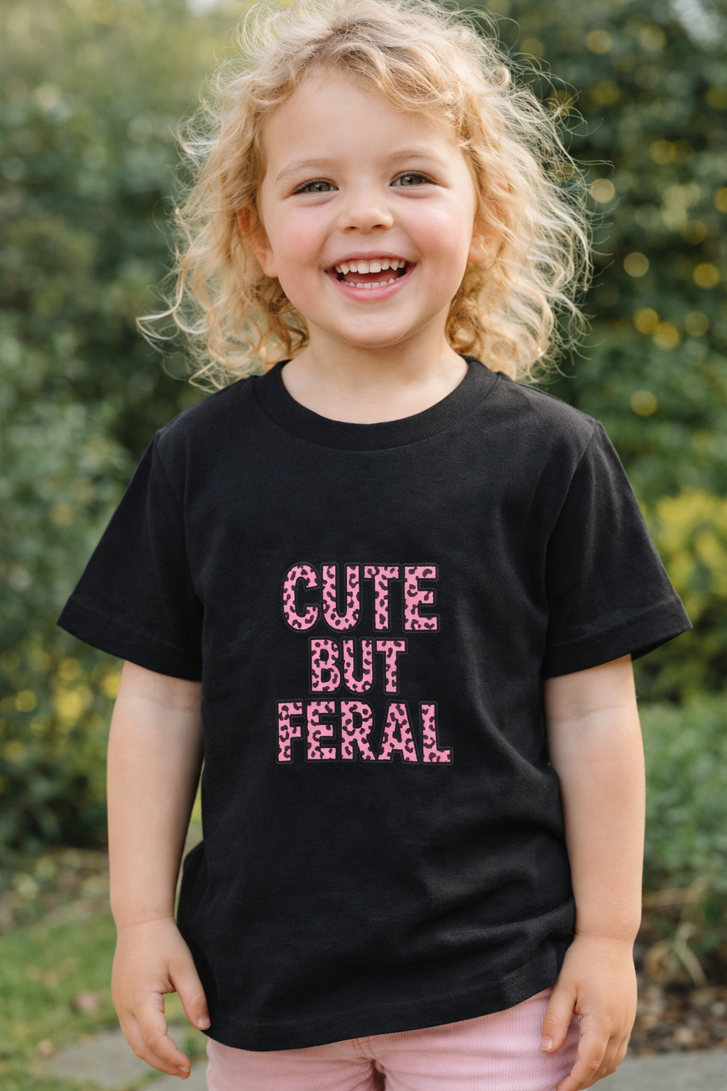 Cute But Feral kids t-shirt in black with pink leopard print text
