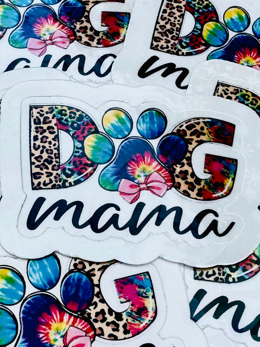Vinyl sticker with the phrase ‘Dog Mama’ featuring leopard print detailing and a bow with paw prints, photographed on a flat surface.