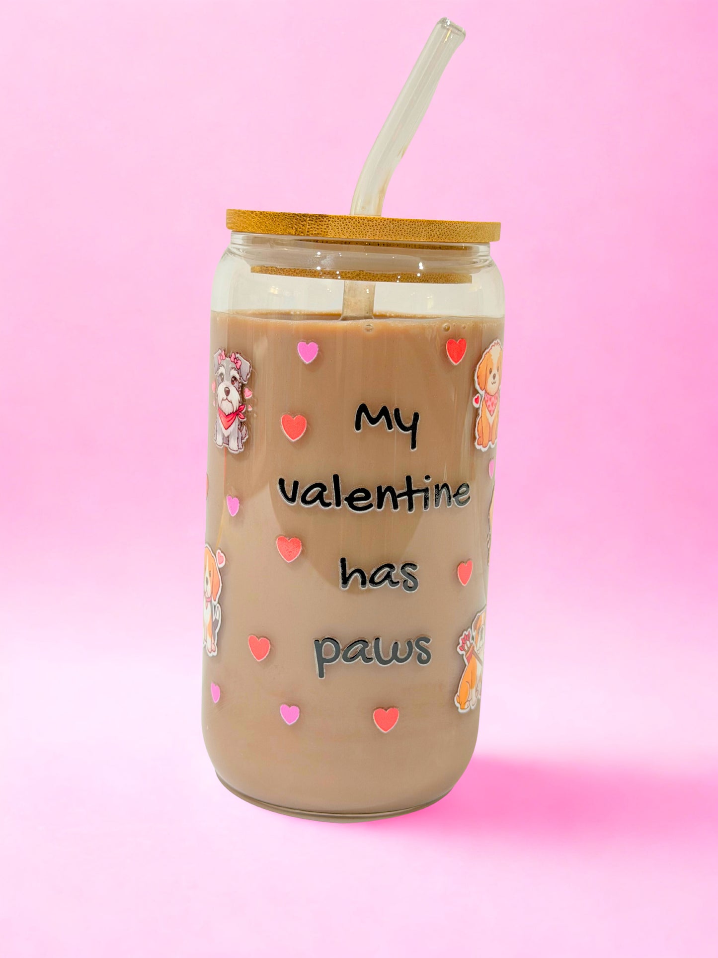 “16oz My Valentine Has Paws glass can cup with bamboo lid and glass straw, dog illustrations and heart design on a pink background.”