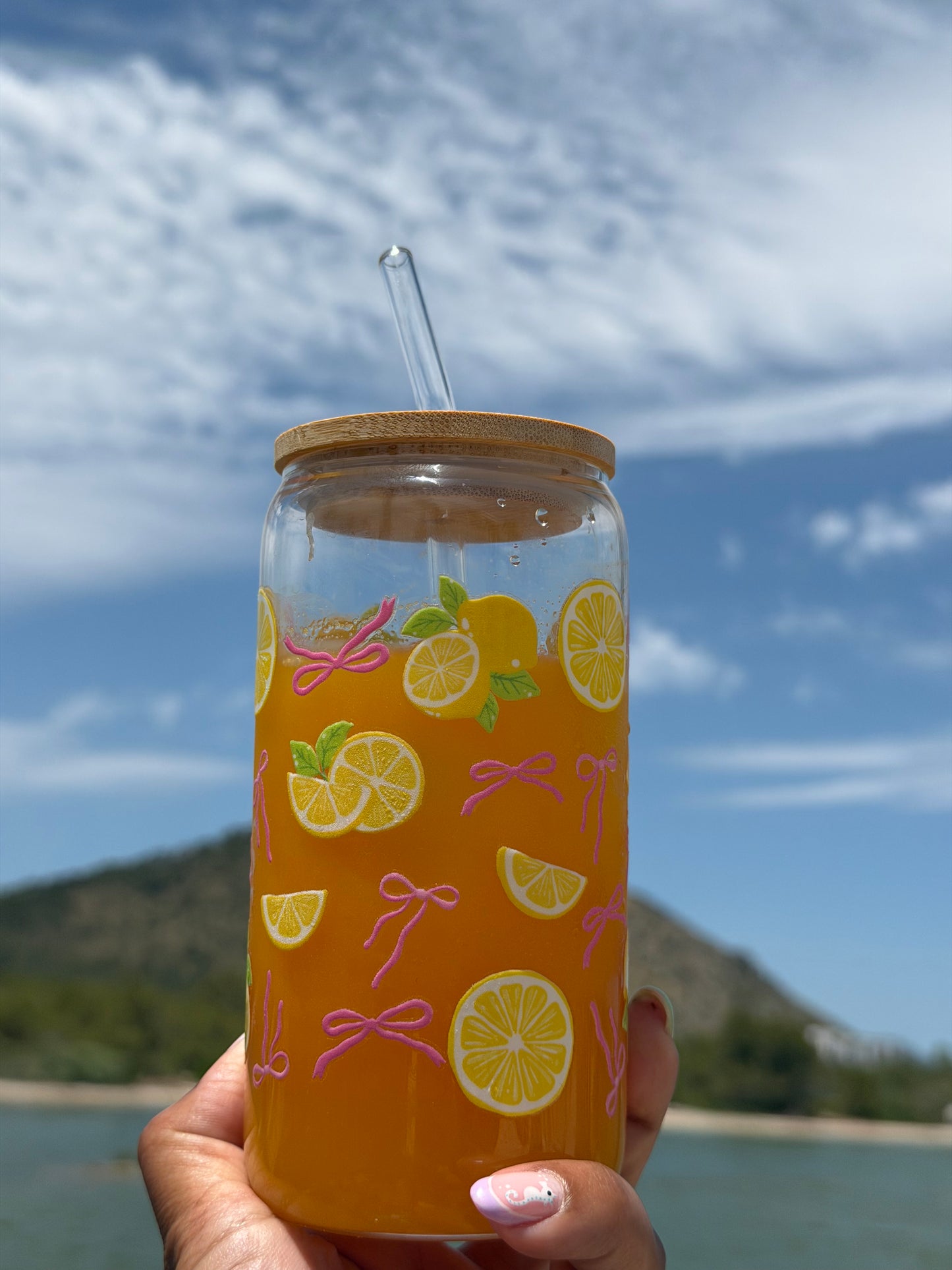 Pink Bows & Lemons Glass Can Cup held by a scenic mountain lake featuring lemon and bow design.