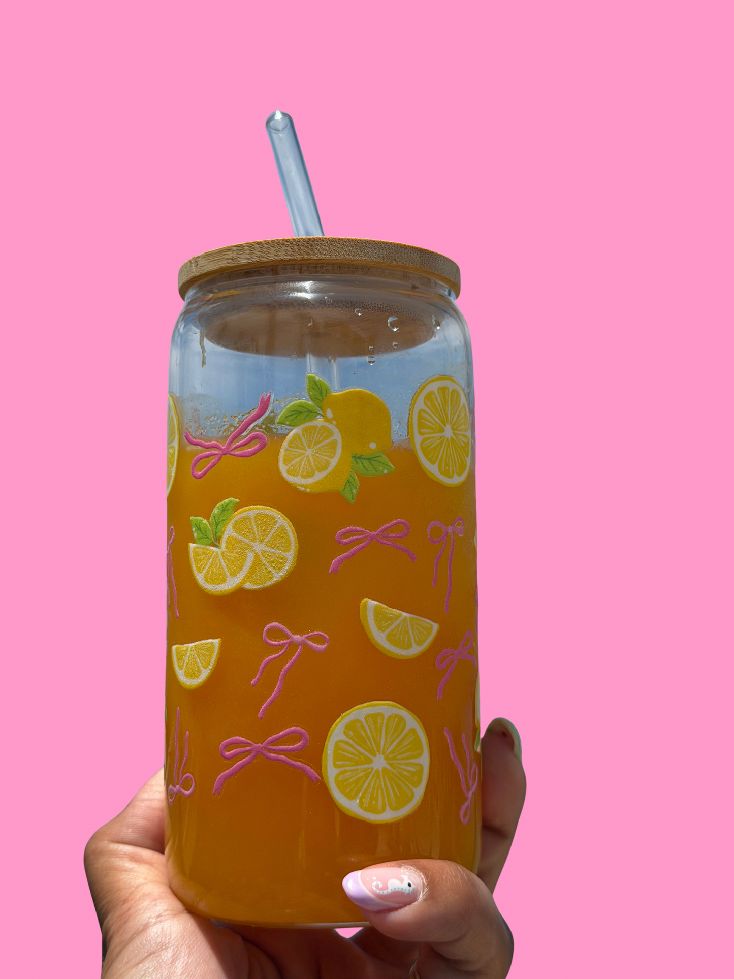 Pink Bows & Lemons Glass Can Cup on pink background with bamboo lid and reusable glass straw.