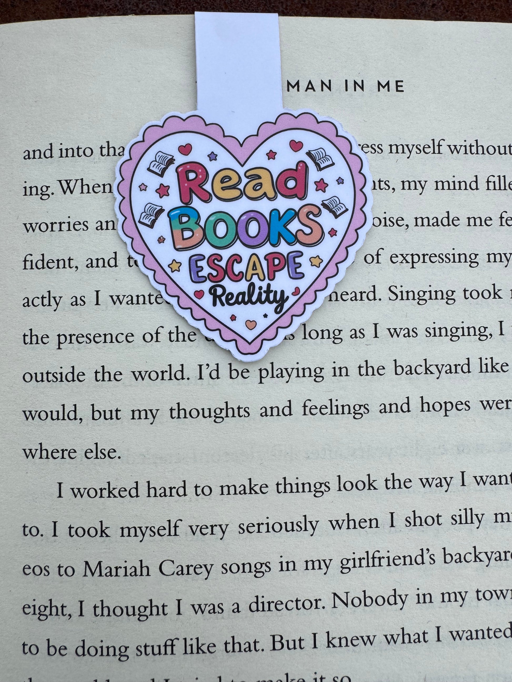 Love heart design stuck to the page by magnetic force inside the heart it says read books escape reality close up