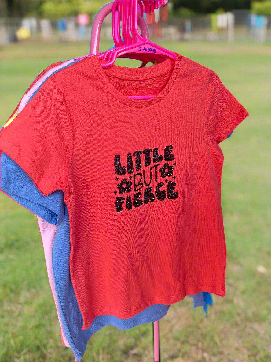 Red kids' T-shirt with the text 'LITTLE BUT FIERCE' printed in black.