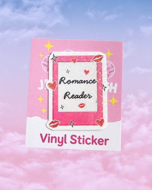 A pink and white vinyl sticker sheet featuring a central frame design with the words 'Romance Reader' in black script, surrounded by red hearts, red lips, and small silver stars. The sheet is displayed against a soft pink and blue cloudy sky background.