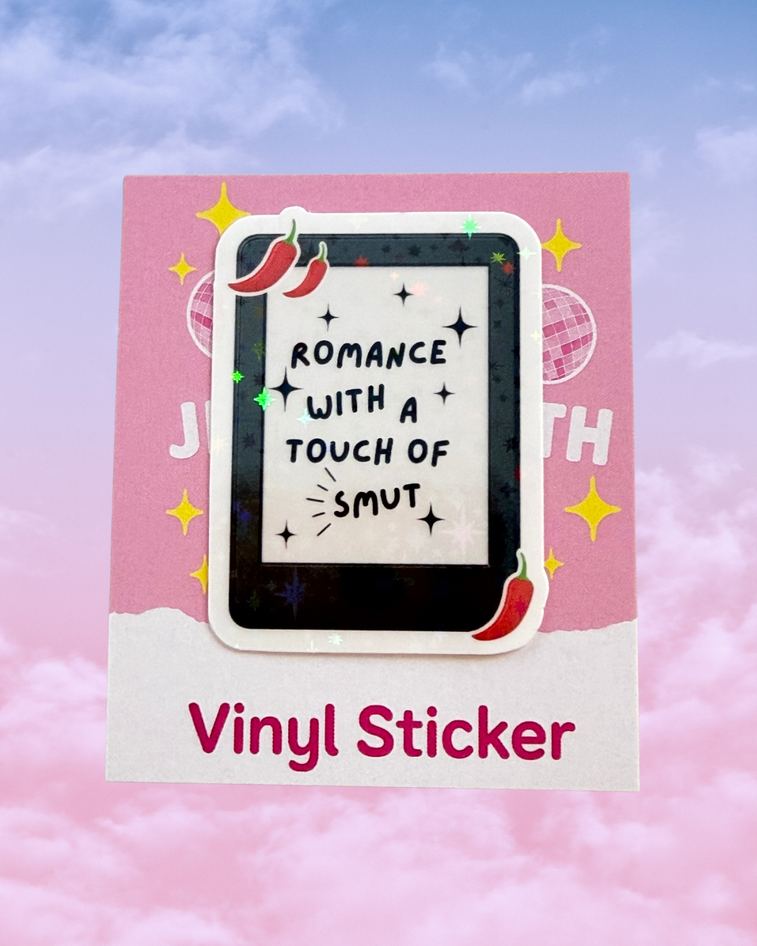 A rectangular pink and white vinyl sticker sheet displayed against a pastel pink-and-blue cloudy background. The sheet features a central die-cut sticker of a black tablet with the phrase “ROMANCE WITH A TOUCH OF SMUT” in black text on a white screen, decorated with red chili peppers and yellow stars.