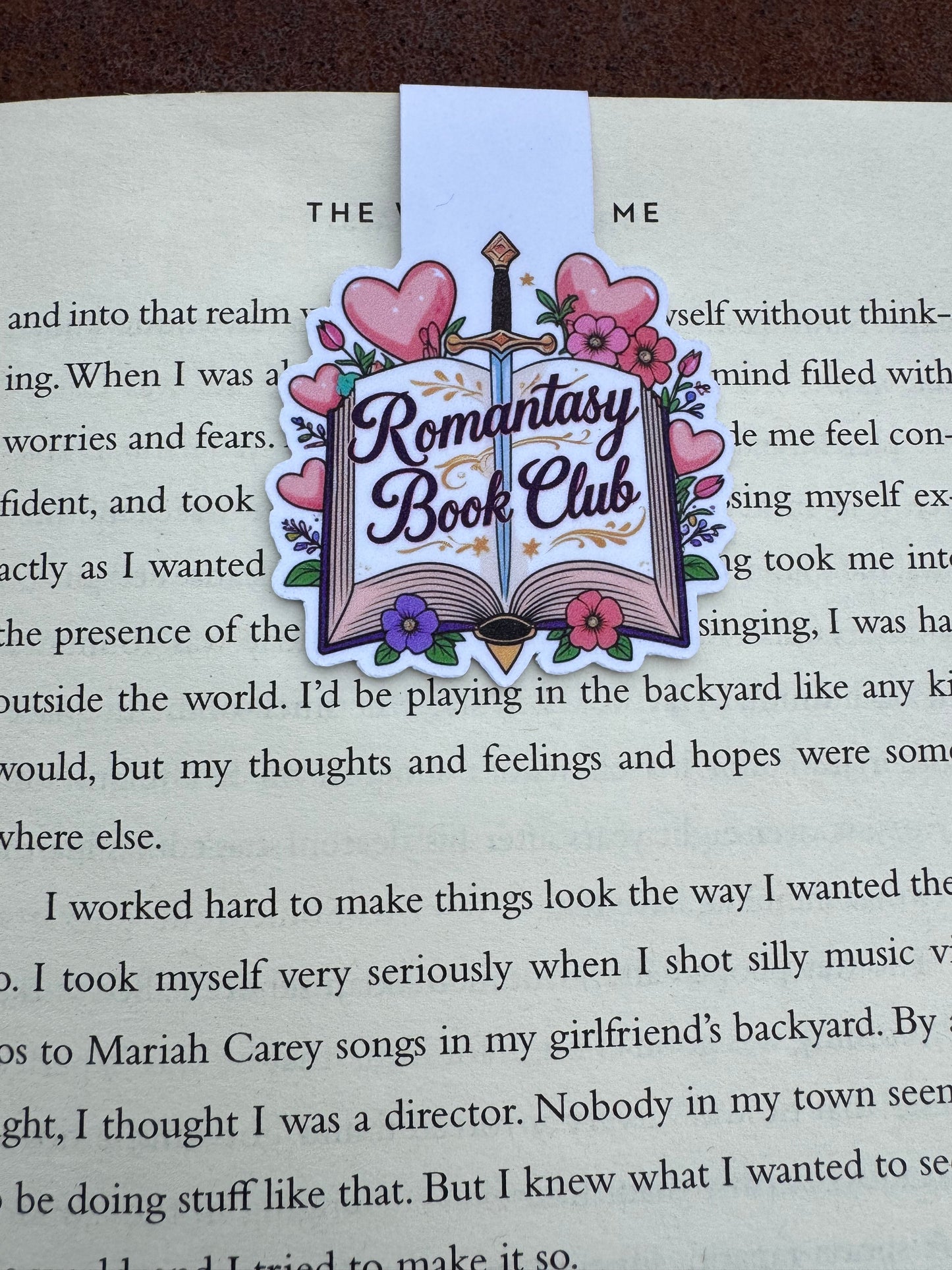 Book with a decorative bookmark featuring 'Fantasy Romance Book Club' text on a page.