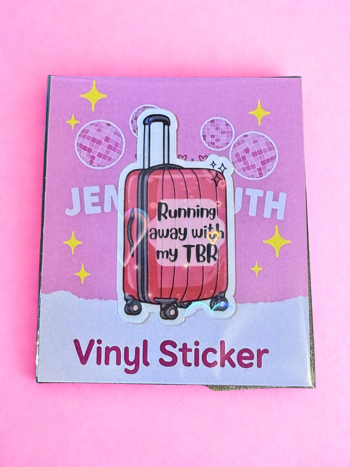 Pink suitcase Running Away With My TBR vinyl sticker with glossy laminate and holographic detail.