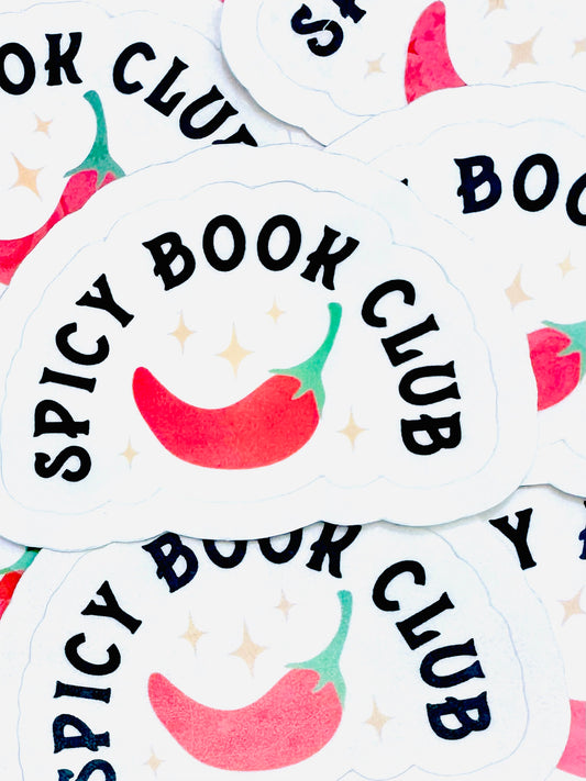 White vinyl sticker with the phrase ‘Spicy Book Club’ in black font next to a red chilli pepper illustration, sized approximately 4cm by 6cm, photographed on a flat surface