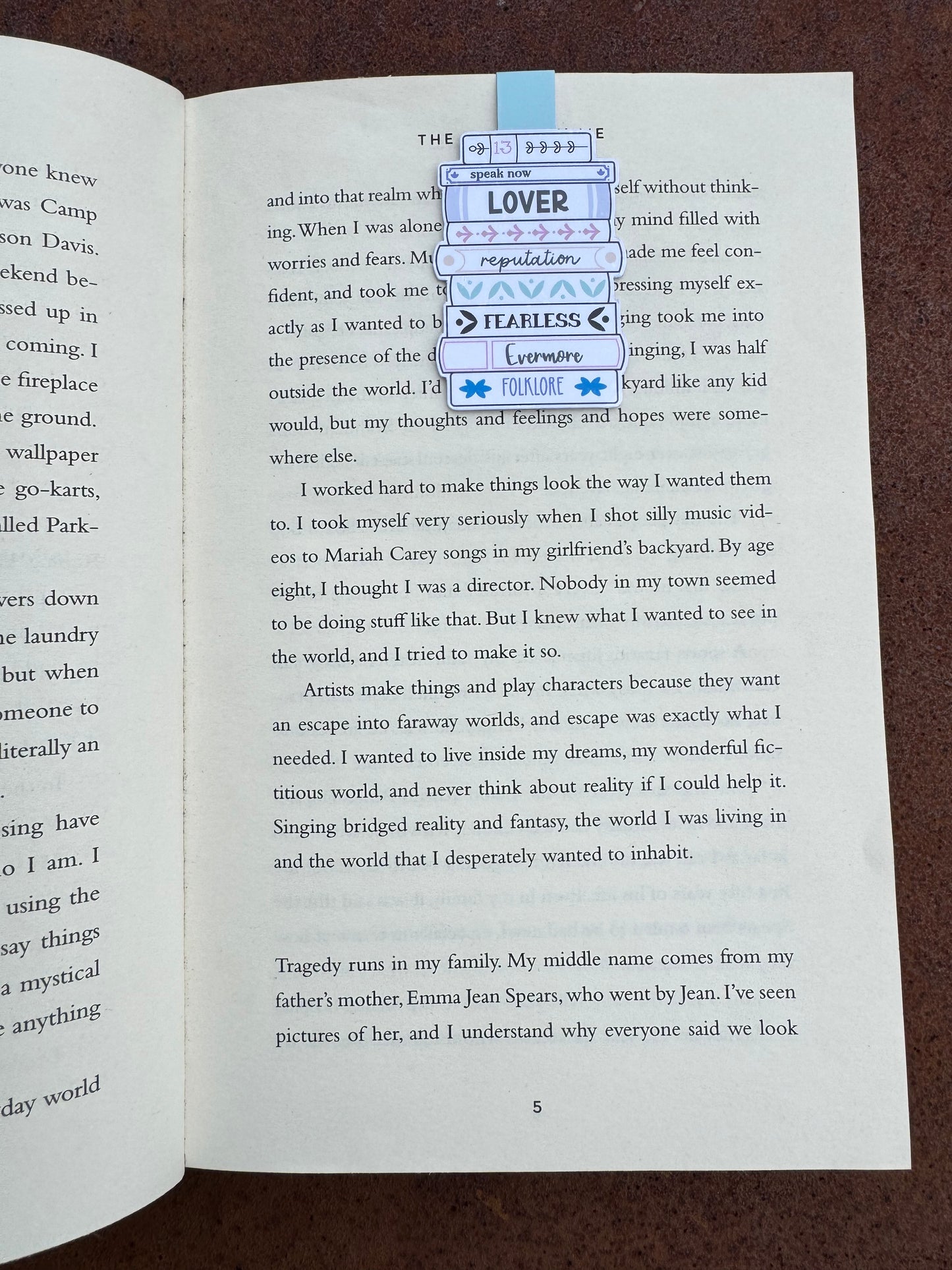 Magnetic bookmark is sat on the page of a book the design is a stack o books with swift album titles on the books