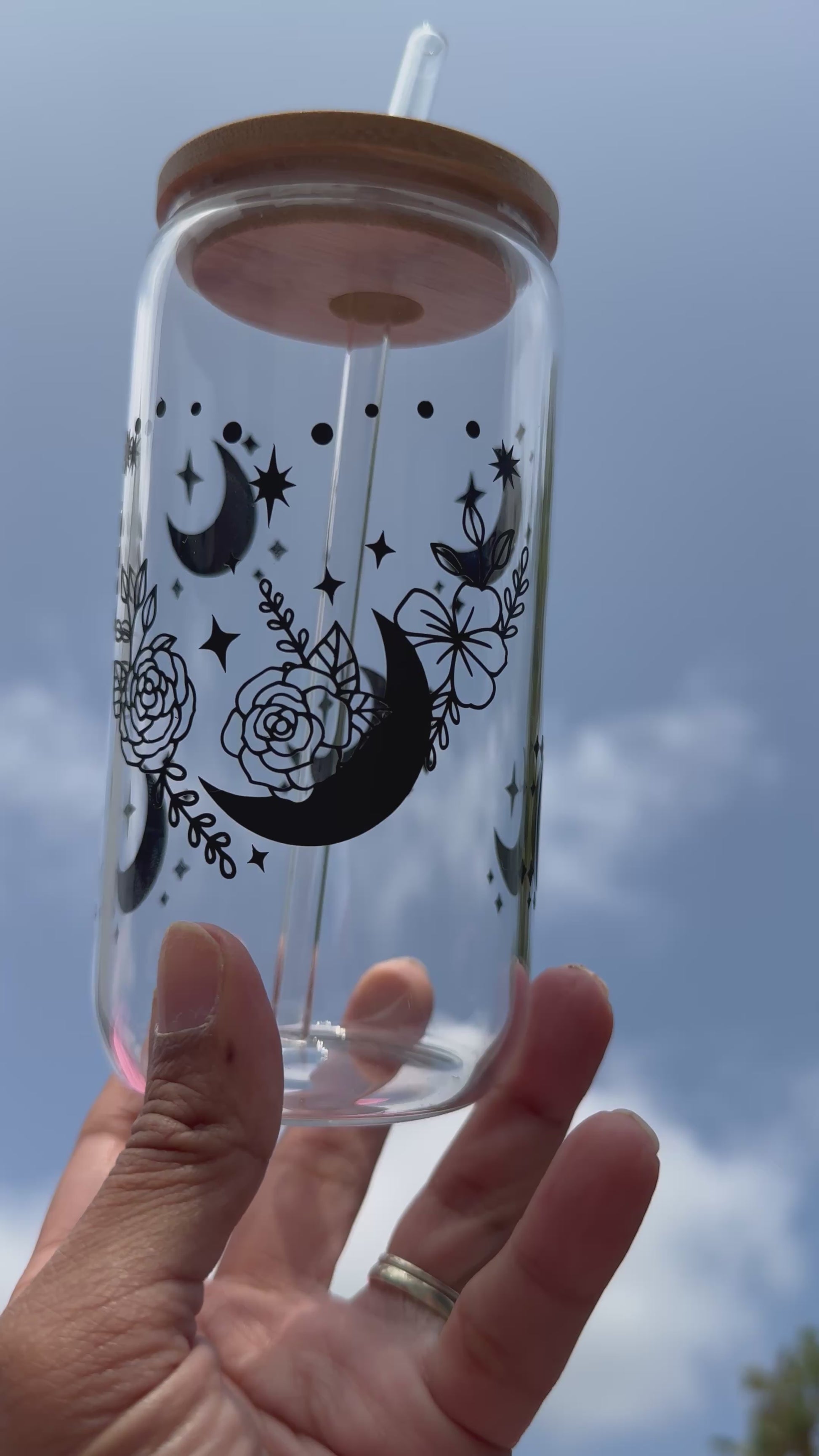 Video shows Moon and roses heart design glass can cup with bamboo lid and reusable glass straw, decorated with moons and stars, 16oz / 480ml.