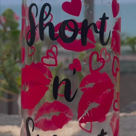 Glass can cup ASMR style with 'short n' sweet' text and red lips design on a stone surface with plants in the background