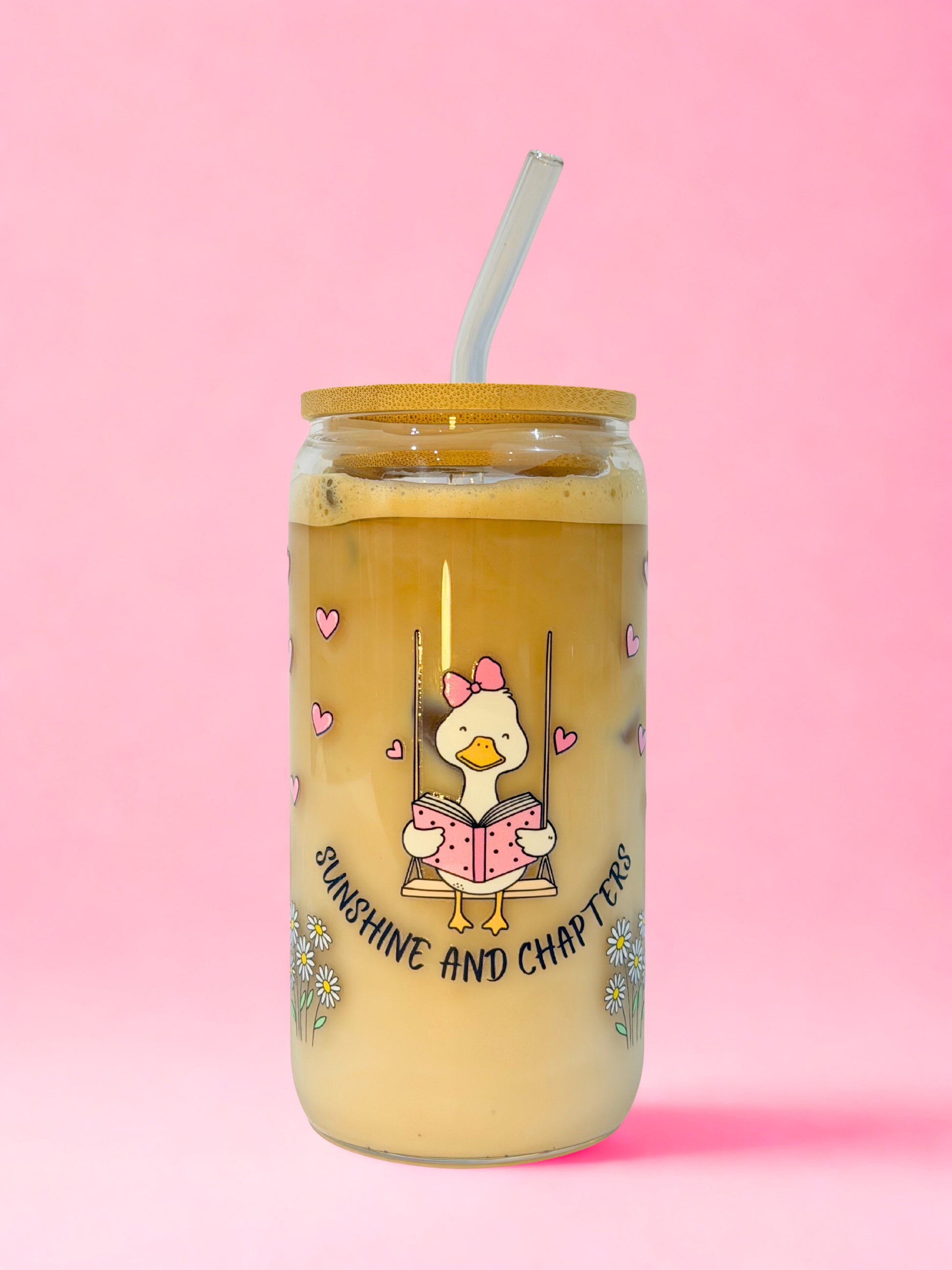 Sunshine and Chapters bookish glass can cup with cute duck reading on a swing surrounded by hearts and daisies